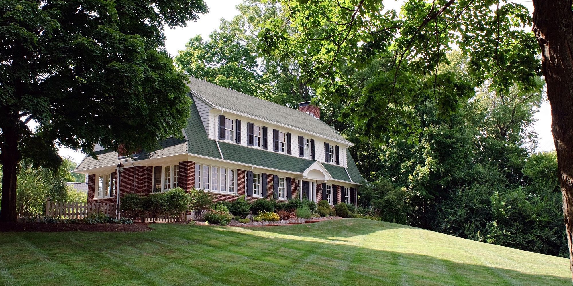 A large house with green roof and white trim.