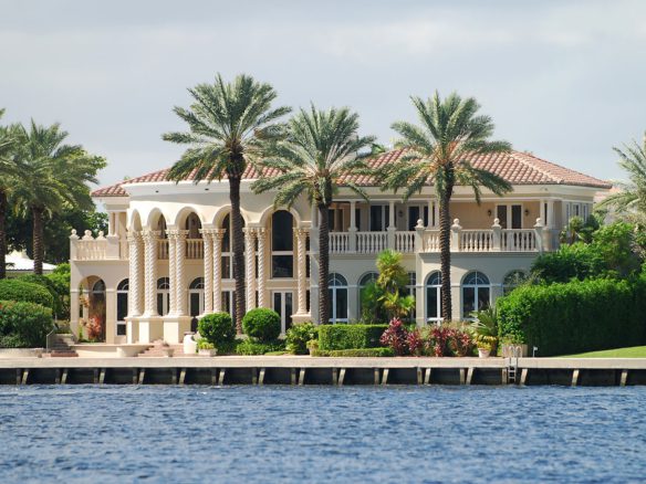 A large white house with palm trees in front of it.