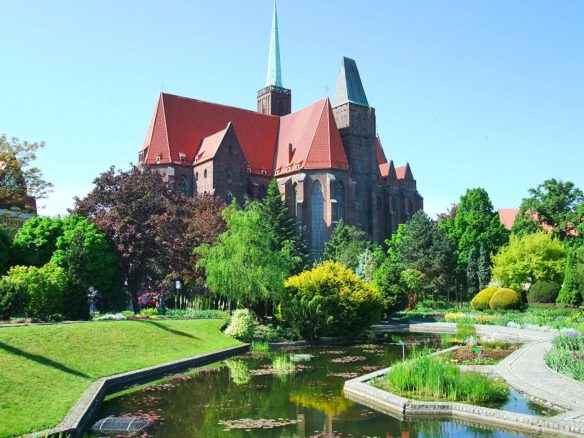 A large church with a pond in the foreground.