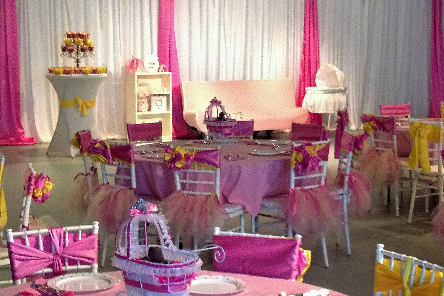 A table set up with pink and white chairs.