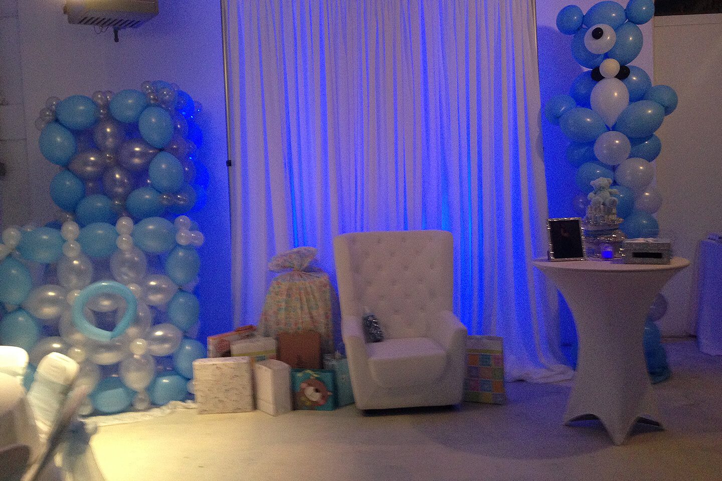 A white chair and some blue balloons