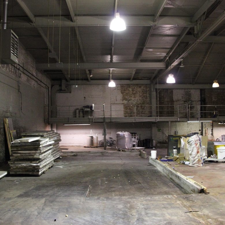 A warehouse with many lights and some concrete floors