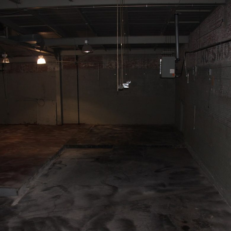 A dark room with concrete walls and floor.
