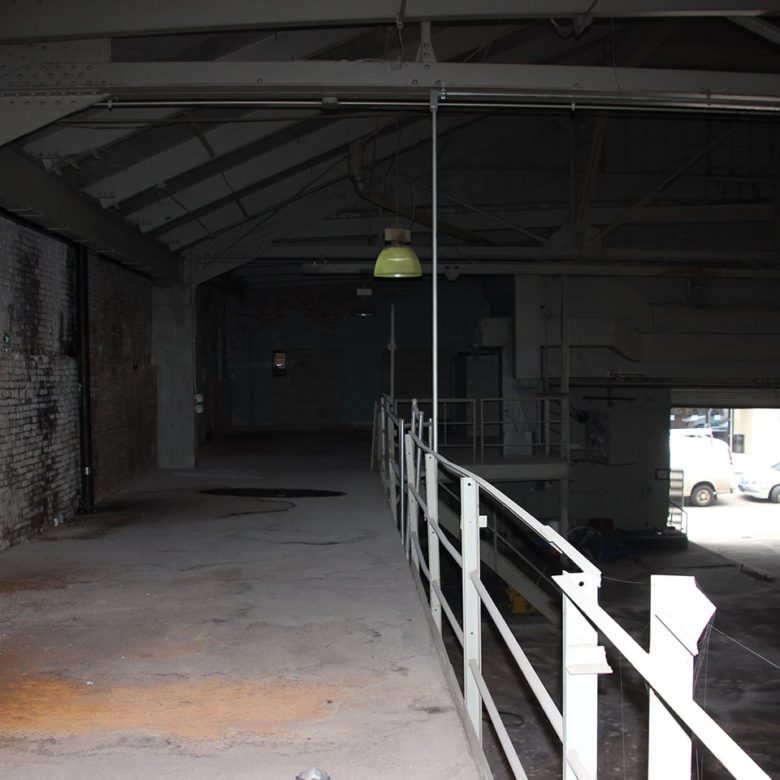 A view of an empty room with a light hanging from the ceiling.