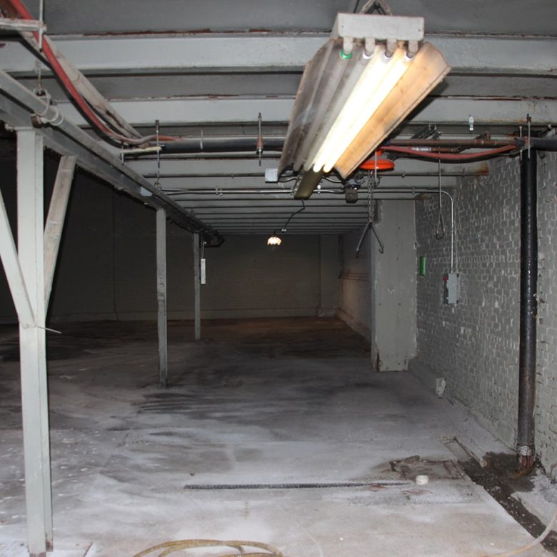 A large empty garage with lights on the ceiling.