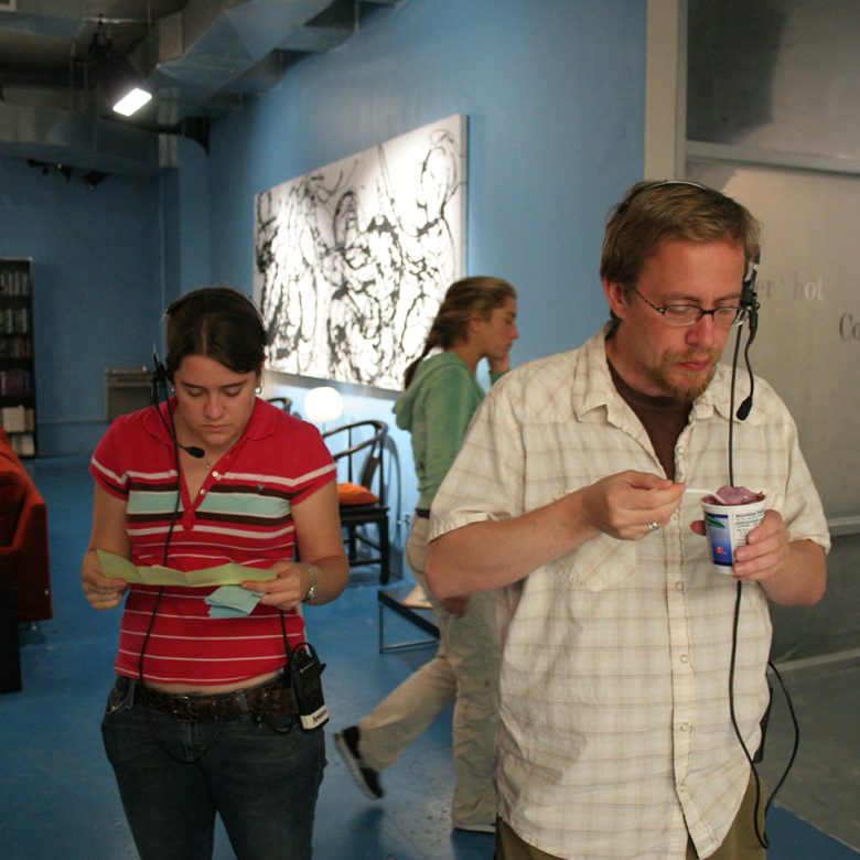 Two people standing in a room with headphones on.