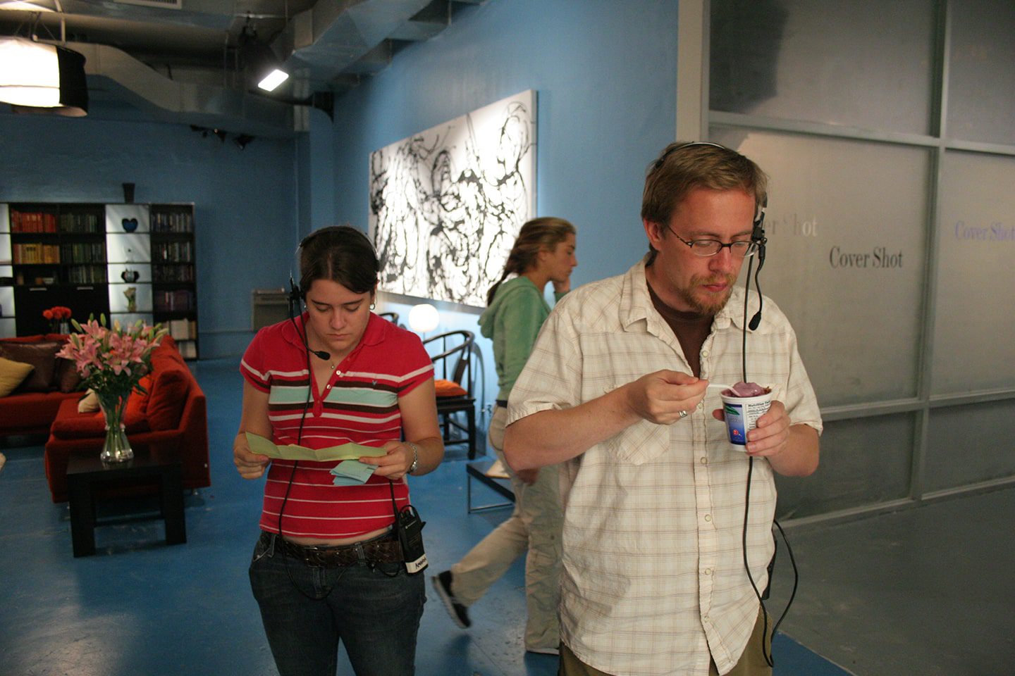 Two people standing in a room with headphones on.