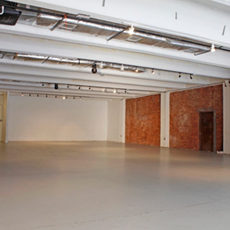 A large empty room with brick walls and white floors.