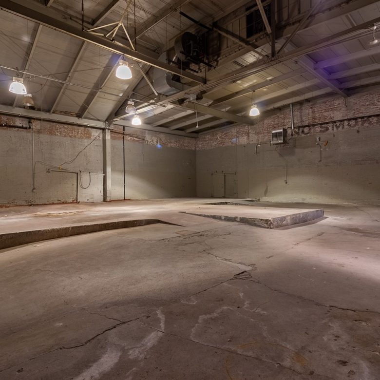 A large empty room with concrete floors and walls.