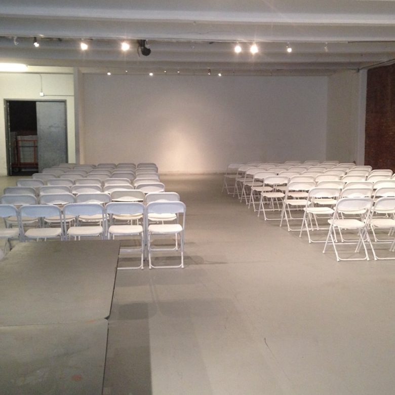 A room with many white chairs and tables
