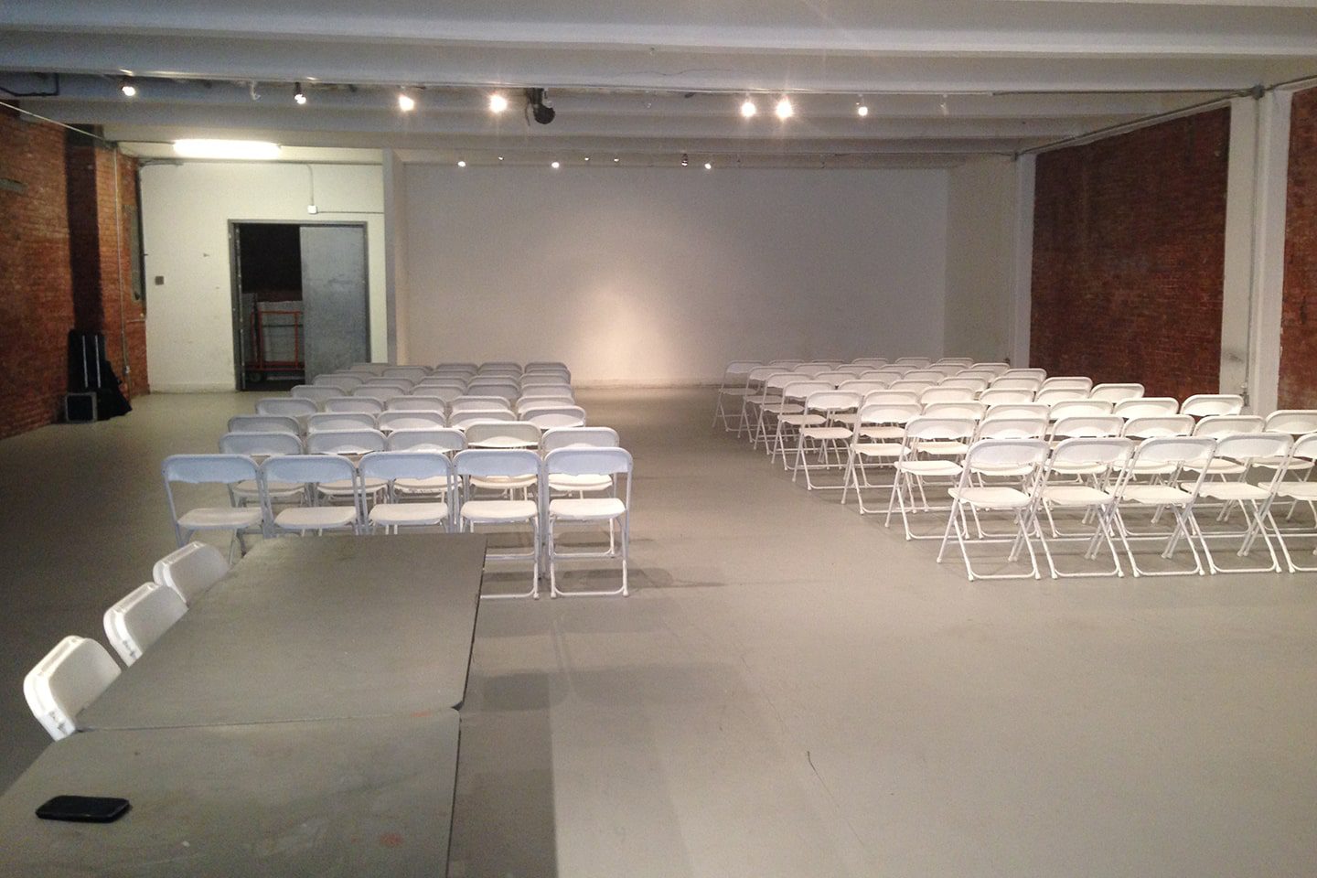 A room with many white chairs and tables